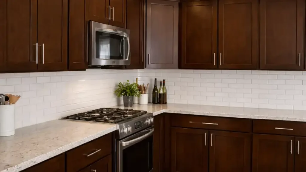 Dark wood kitchen cabinets installed with white subway tile backsplash and stainless steel appliances