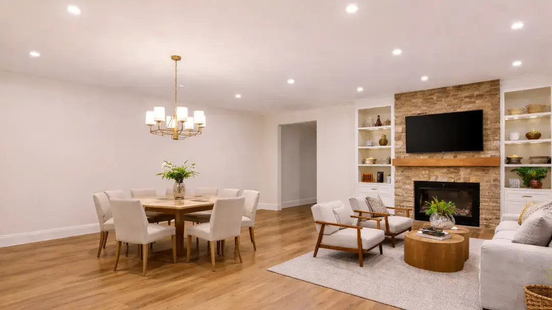Open living and dining area with fireplace and wood flooring
